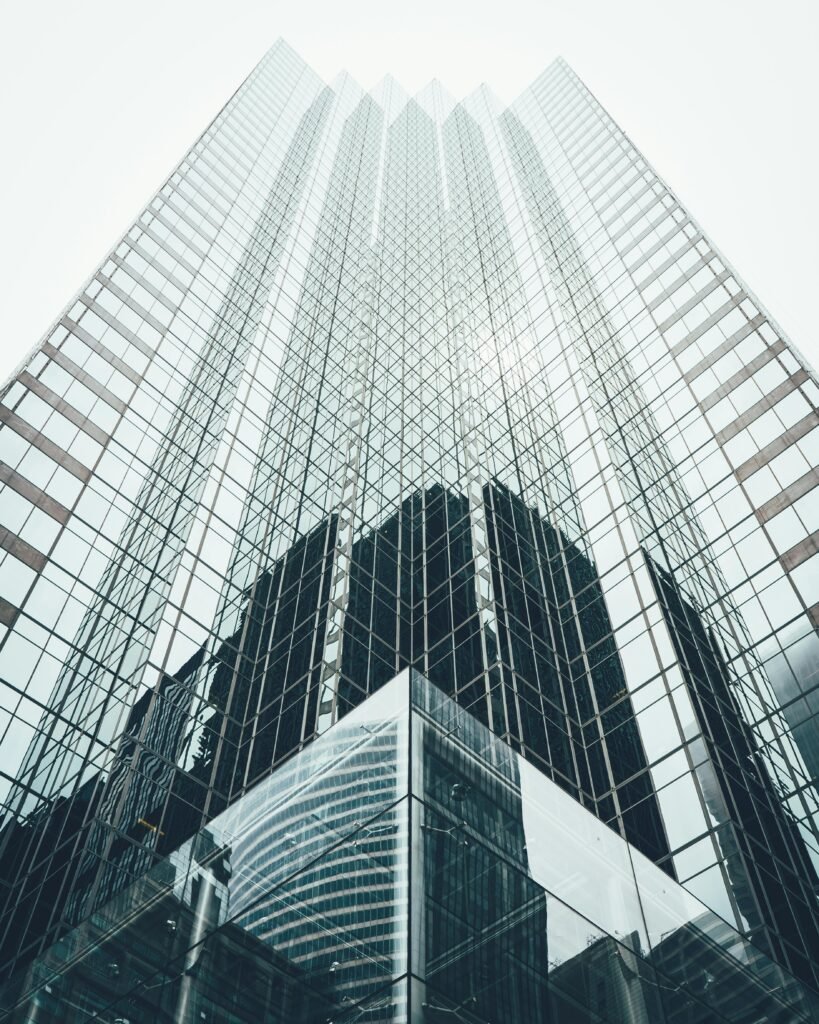 pexels-photo-1662159-1662159 Striking low angle view of a modern skyscraper with reflective glass facade in a cityscape.